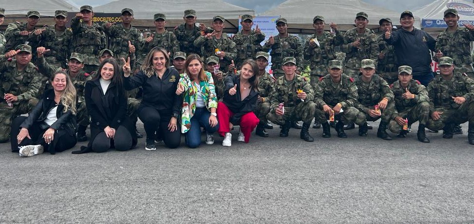 Equipo de COOPCELTEC y militares posan juntos en una feria de servicios
