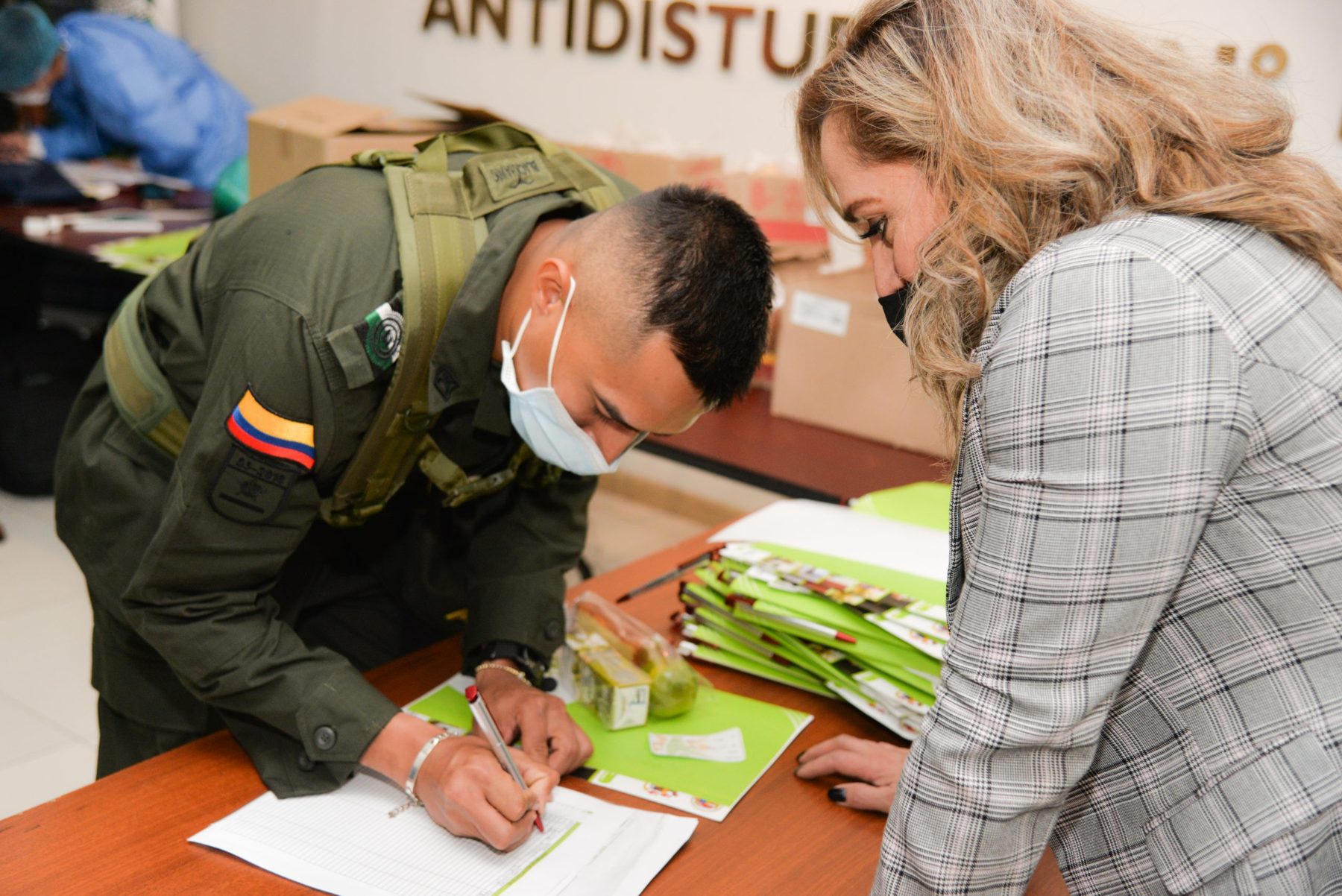 Asesora de COOPCELTEC atendiendo a un miembro de la Policía Nacional en una jornada